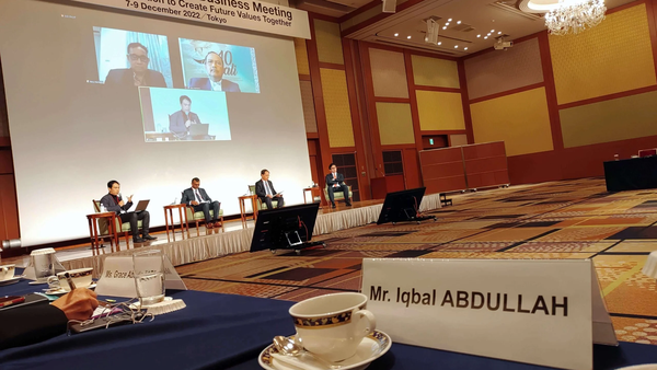 Photo of the 48th ASEAN-Japan Business Meeting with a banner, speakers on stage, and a name card for Mr. Iqbal ABDULLAH.