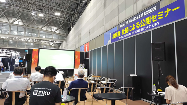 Photograph of a seminar at Japan IT Week Nagoya 2022 with a blue banner reading "出展社社長による公開セミナー"